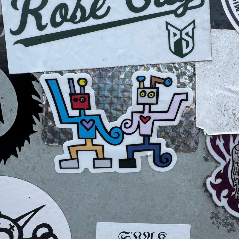 Load image into Gallery viewer, Love Robot Sticker - stick on top of some other stickers on a wall
