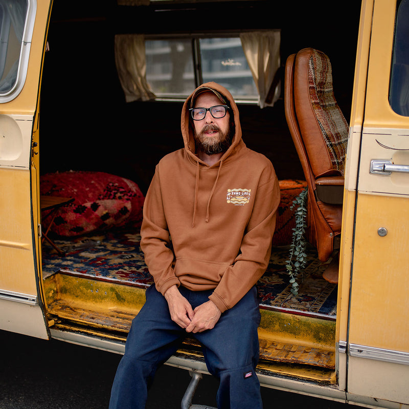 Load image into Gallery viewer, Mid Tide Hoodie - Front - man sitting in van wearing the hoodie.
